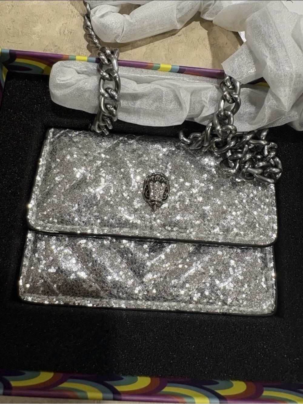 silver glitter kurt geiger purse with chain shoulder strap. text 5045474637.